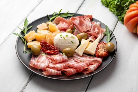 Dish of delicious cheeses and cold cuts, italian appetizers, european food