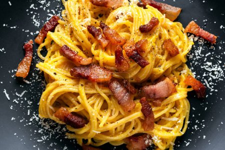Photo for Plate of delicious pasta alla carbonara, a traditional recipe of pasta with egg sauce, guanciale, pecorino and black pepper, european food - Royalty Free Image