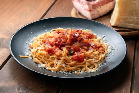 Deliciosos espaguetis amatriciana, una receta tradicional de pasta con salsa de tomate, guanciale y pecorino de cocina romana, comida italiana 