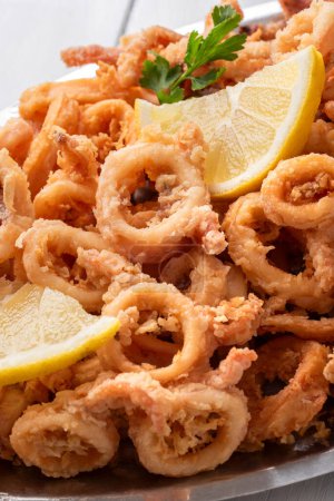 Foto de Primer plano de la bandeja de anillos de calamar fritos, comida italiana, merienda mediterránea - Imagen libre de derechos