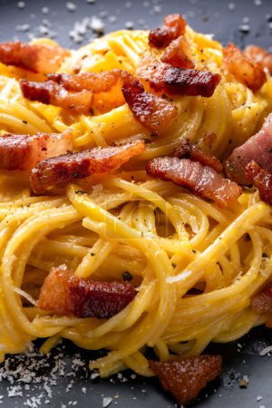 Photo for Delicious spaghetti carbonara, a traditional roman recipe of pasta with egg, guanciale, pecorino and black pepper, italian food - Royalty Free Image