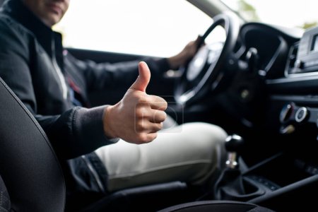 Photo for Happy driver in car, thumbs up. Man driving. Smiling positive new vehicle buyer and owner. Good customer service in taxi, dealership, insurance, inspection or maintenance business. Success in repair. - Royalty Free Image