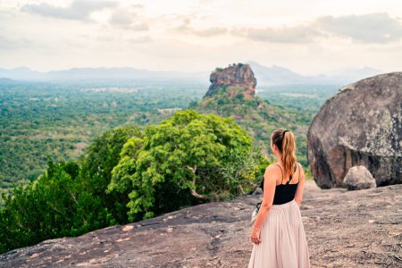 Téléchargez les photos : Femme à Sigiriya, Sri Lanka. Voyage dans la belle nature. Paysage de montagne et forêt. Bonne fille. Touriste regardant Lion's Rock de la colline de Pidurangala. Tourisme, exploration et liberté. - en image libre de droit