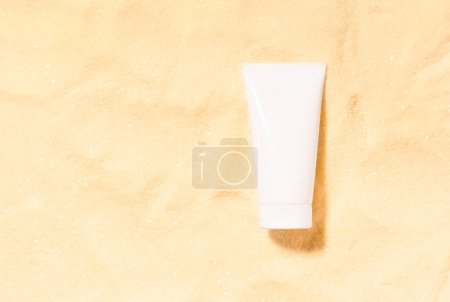 Photo for Mockup sunscreen cream or lotion bottle. Summer sun protection template scene with white cosmetic tube on a yellow sand. Product presentation or package advertisement. - Royalty Free Image