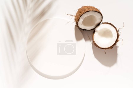 Photo for Cosmetic product design, product presentation scene made with white circle mockup podium and coconuts. Sunny background. Top view. - Royalty Free Image