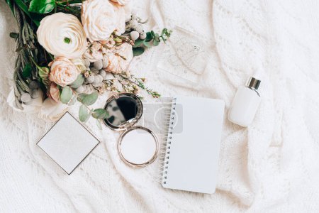 Photo for Flat lay scene made with cosmetics accesories, elegant flowers bouquet and empty mockup spiral notebook. - Royalty Free Image