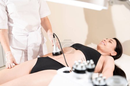 Photo for Cavitation fat burning treatment of abdominal area for young woman in beauty clinic - Royalty Free Image