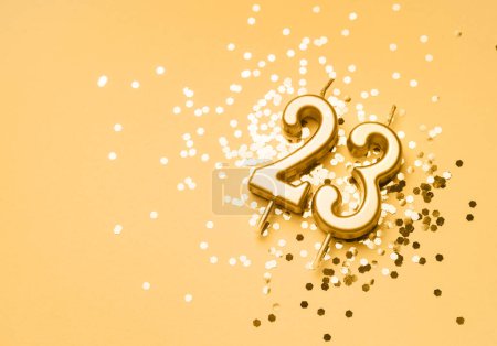 Photo for 23 years birthday celebration festive background made with golden candle in the form of number Twenty three lying on sparkles. Universal holiday banner with copy space. - Royalty Free Image