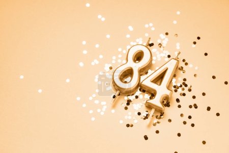 Photo for 84 years celebration festive background made with golden candles in the form of number Eighty-four lying on sparkles. Universal holiday banner with copy space. - Royalty Free Image