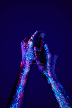 Foto de Close-up hands with fluorescent paintings in neon bold colors. Modern psychedelic creative element with human palm for posters, banners, wallpaper. Copy space for text. Magazine style. Zine culture. - Imagen libre de derechos