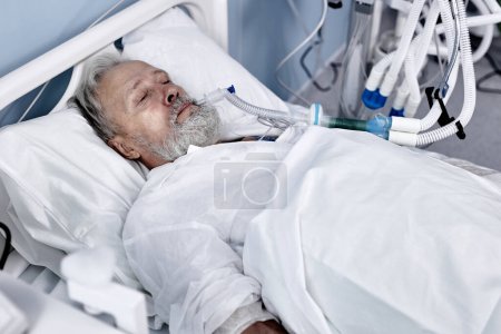 Téléchargez les photos : Caucasian aged man patient lying on bed at hospital ward. Lonely old man sleeping in Nursing home. Retired male is suffering from disease, coronavirus and covid-19. medicine, health, people concept - en image libre de droit