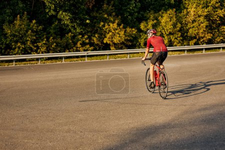 Photo for Rear view on young caucasian man wearing sport uniform and glasses riding great bike, going in for favorite activity. handsome guy in sportive outfit is engage in sport, healthy lifestyle - Royalty Free Image