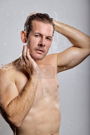 Téléchargez les photos : Handsome macho man guy holding hands touch perfect hairdo topless sporty torso metrosexual hot tender body isolated over grey background. Portrait of naked muscular model of caucasian appearance - en image libre de droit