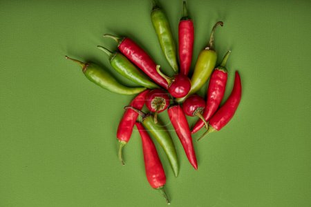 Téléchargez les photos : Creative layout of chili pepper on green background. Minimal food concept. copy space. top view on fresh red and green peppers vegetables - en image libre de droit