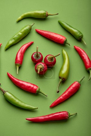 Foto de Flat lay composition with many hot chili peppers on green background. fresh fruits vegetables concept. top view, above view. agriculture - Imagen libre de derechos