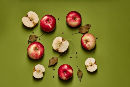Photo for Red apple with half isolated on green background with full depth of field. Top view. Flat lay with copy space for your text - Royalty Free Image