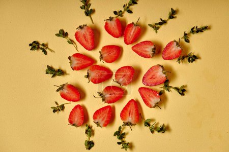 Foto de Top view on strawberry fruits with leafs lying on yellow background, flat lay. copy space - Imagen libre de derechos