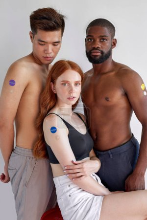 Téléchargez les photos : Stay at home. Young people are vaccinated. Flu epidemic, protection against virus omicron. COVID-19, coronavirus pandemic. Portrait of black american, asian and caucasian youth, half-naked - en image libre de droit