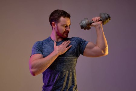 Photo for Strong well-built man prouds of his perfect body, biceps, happiness, success, good results. isolated purple background. - Royalty Free Image