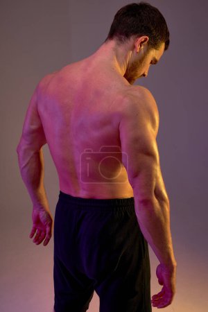 Photo for Strong massive big sweaty back of bodybuilder. close up portrait, isolated brown background, health and body care. man in black shorts looking down while standing at studio - Royalty Free Image