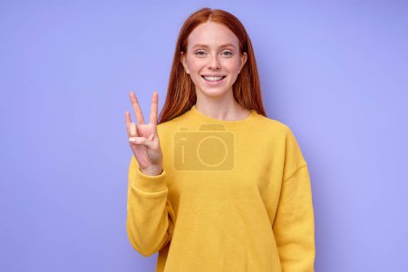 Foto de Chica alegre mostrando la letra N con los dedos. el alfabeto en el lenguaje de señas americano ASL. retrato de primer plano de fondo azul aislado - Imagen libre de derechos