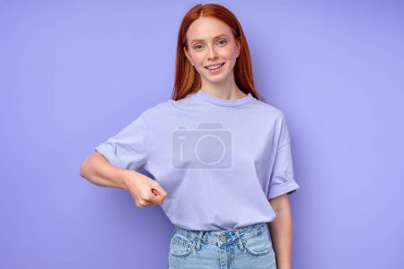 Photo for Smiling redhead girl raising her arm with clenched fist. close up portrait isolated blue background - Royalty Free Image