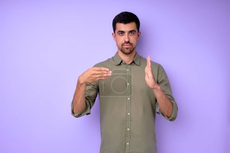 Photo for Young serious bearded deaf mute man showing number 400 using sign language on blue background isolated close up portrait - Royalty Free Image