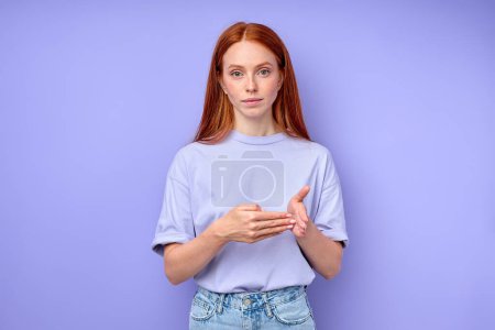 Photo for Young red-haired good-looking girl working as a Sign language interpreter , studio shot, closeup portrait isolated blue background 100 number - Royalty Free Image