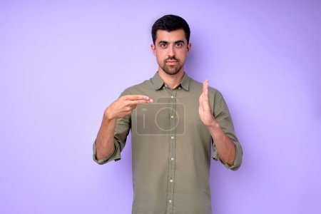 Photo for Young serious bearded deaf mute man showing number 200 using sign language on blue background isolated close up portrait - Royalty Free Image