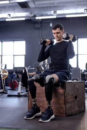 Photo for Young active ambitious injured person doing sport Recovery of a lost limb using modern technology. love of life. strong guy trying to raise dumbbells over his head. strength health care. cross fit - Royalty Free Image