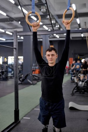 Photo for Love of life. tired sweaty man holding gymnastic rings, looking at the camera, tiredness, man keeps fit, exhausted sportsman after hanging on rings - Royalty Free Image