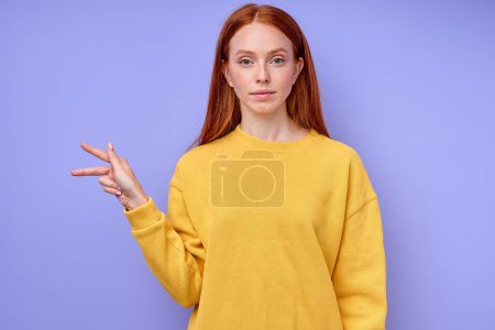 Foto de Letra K ortografía por las niñas mano en American Sign Language ASL sobre fondo azul, primer plano retrato, mujer caucásica confiada demostrando la letra K. símbolo de lenguaje de signos para sordos humanos - Imagen libre de derechos