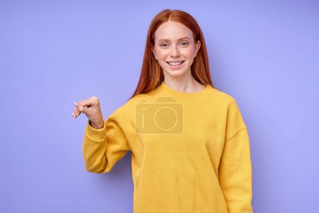 Photo for Letter T spelling by girls hand in American Sign Language ASL on blue background, closeup portrait, happy smiling Caucasian woman demonstrating the letter T. sign language symbol for deaf human - Royalty Free Image
