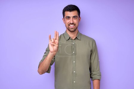 Photo for Happy handsome smiling deaf mute man using sign language on blue background - Royalty Free Image