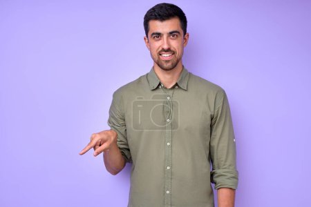 Photo for Cheerful brunette bearded man demonstrating the letter Q q . sign language symbol for deaf human in blue background. isolated - Royalty Free Image