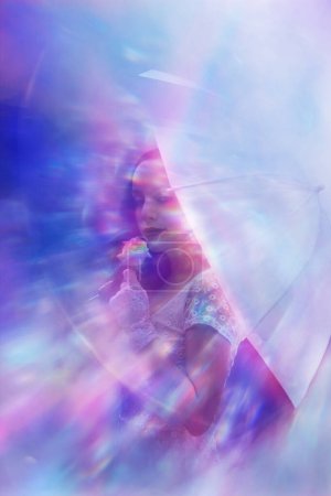 Foto de Los rayos del arco iris están coloreando una rosa, elegantemente sostenida por una mujer clásica con guantes blancos y un paraguas. - Imagen libre de derechos