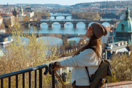 trendy solo traveller woman in white sweatshirt in Prague Czech Republic enjoying promenade.