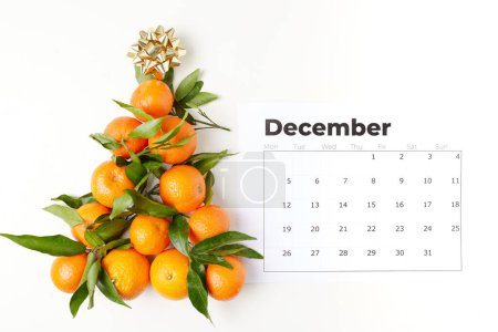 Téléchargez les photos : Hiver plat laïc avec mandarines en forme d'arbre de Noël et calendrier de décembre. - en image libre de droit