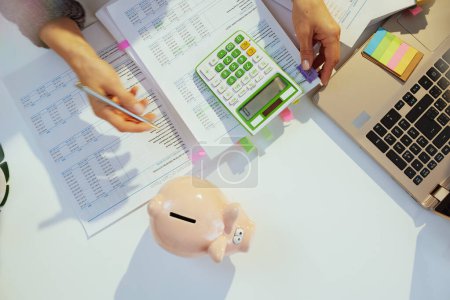 Foto de Tiempo de impuestos. alcancía y contable mujer con calculadora y documentos que trabajan en la oficina. - Imagen libre de derechos