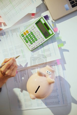 Photo for Tax time. piggy bank and accountant woman with calculator and documents working in office. - Royalty Free Image