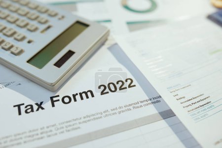 Photo for Tax form 2022 and calculator at desk. - Royalty Free Image
