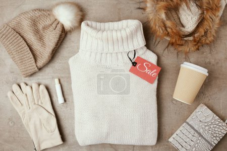 Foto de Piso de invierno con sombrero, bufanda, guantes, taza de café, etiqueta de venta y suéter. - Imagen libre de derechos
