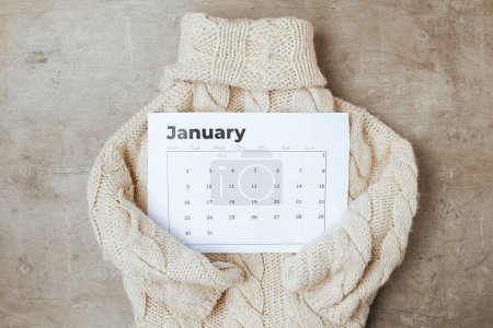 Winterflache lag mit Januarkalender und Pullover.