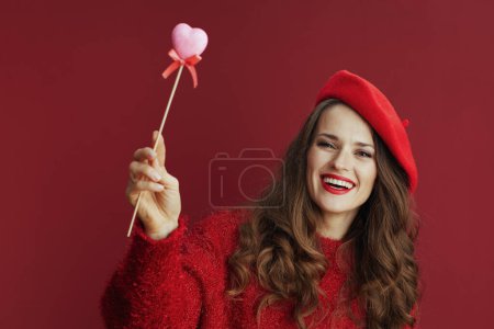 Photo for Happy Valentine. happy stylish woman in red sweater and beret with heart on stick. - Royalty Free Image
