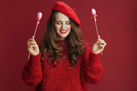 Photo for Happy Valentine. smiling elegant middle aged woman with long wavy hair in red sweater and beret and hearts on stick. - Royalty Free Image