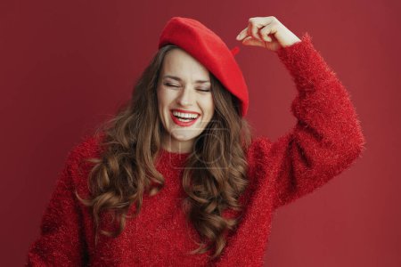 Téléchargez les photos : Joyeux Valentin. femme élégante souriante aux longs cheveux ondulés en pull rouge et béret. - en image libre de droit
