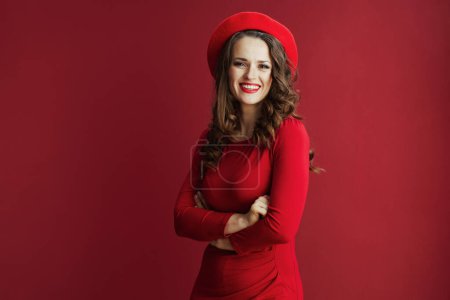 Photo for Happy Valentine. Portrait of smiling stylish woman with long wavy hair in red dress and beret on red background. - Royalty Free Image