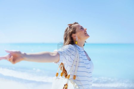 Téléchargez les photos : Heureuse femme élégante à la plage se réjouissant. - en image libre de droit