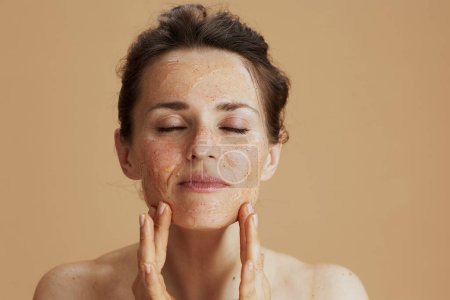 Photo for Modern woman with face scrub isolated on beige. - Royalty Free Image