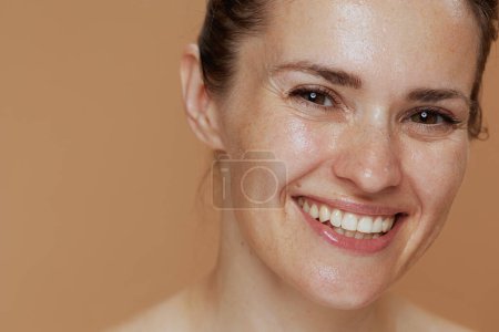 Téléchargez les photos : Heureuse jeune femme avec humide visage lavage isolé sur fond beige. - en image libre de droit